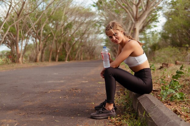 公園で水を飲む女性。バリ