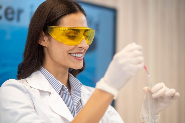 Woman dripping water from pipette into test tube