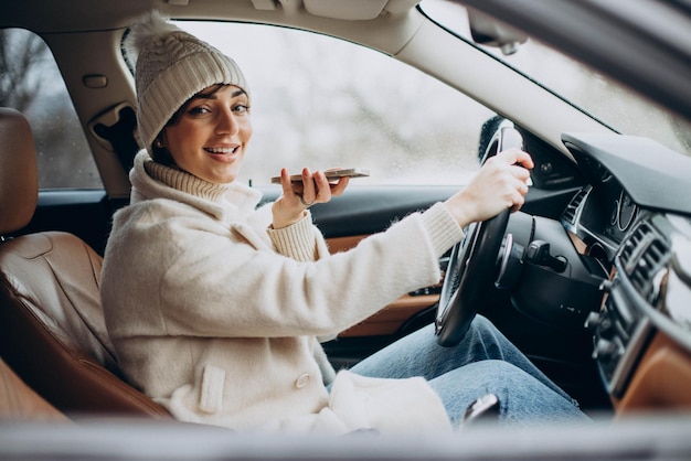 車で運転し、電話を使用している女性