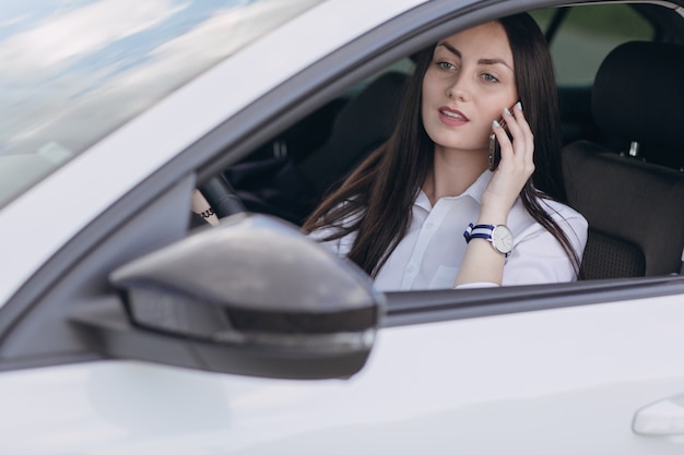 Woman driving a car while talking on the phone