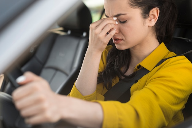 運転して頭痛を持っている女性