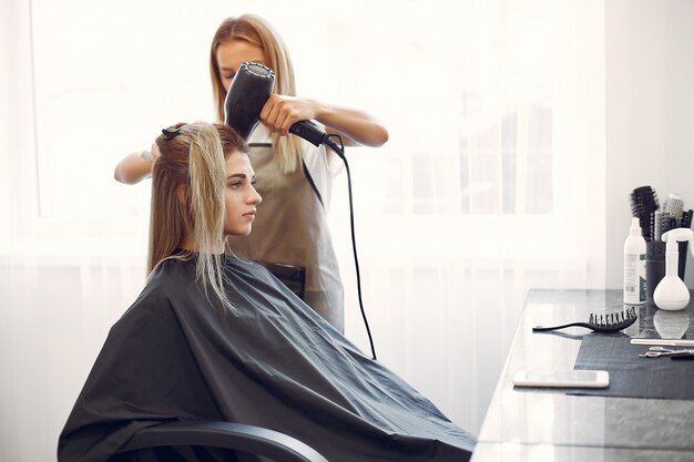 Женщина сушит волосы в парикмахерской
