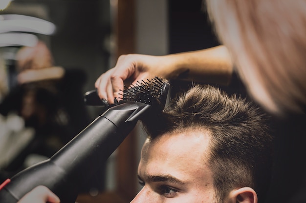 Donna che asciuga e acconciatura capelli dell'uomo