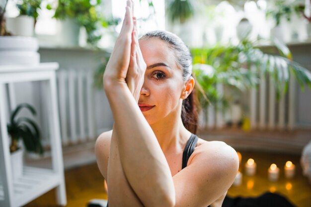 Woman in eagle pose looking at camera