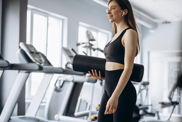 Donna in auricolari che ascolta la musica in palestra