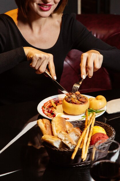 レーズンニンジンと肉を詰めた焼きマルメロを食べる女性