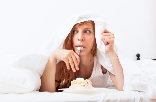 woman eating  cake under sheet