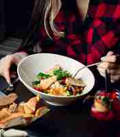 Free photo woman eating chicken salad with boiled vegetable