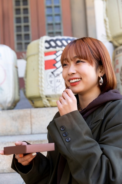 Free photo woman eating chocolate sweets outdoors