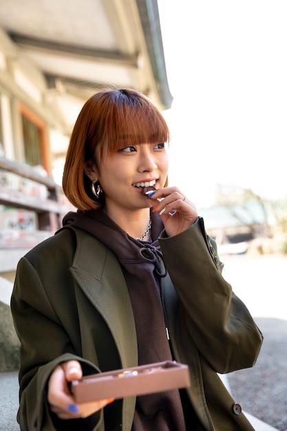 屋外でチョコレート菓子を食べる女性