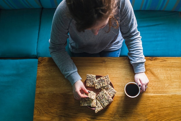 Woman eating cookies with hot drink