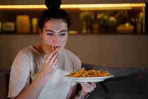 Free photo woman eating fast food while watching a movie