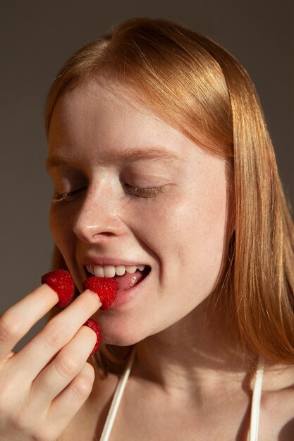 新鮮なラズベリーの側面図を食べる女性