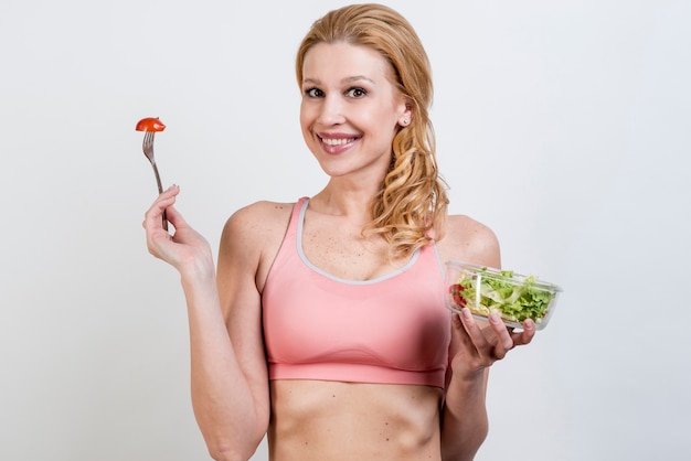 Foto gratuita donna che mangia un'insalata di lattuga