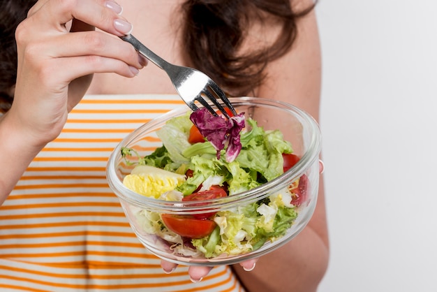 Donna che mangia un'insalata di lattuga