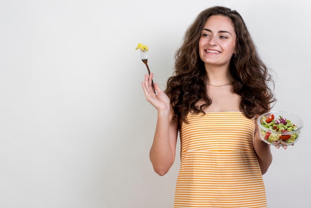 Donna che mangia un'insalata di lattuga