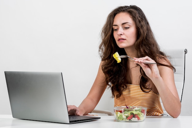 Free photo woman eating a lettuce salad