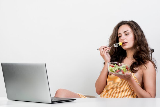 Donna che mangia un'insalata di lattuga