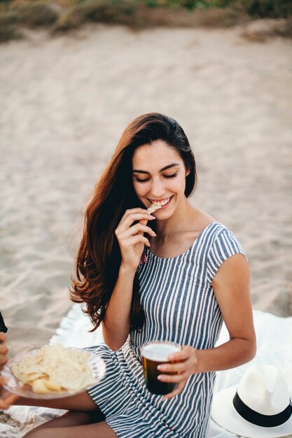 Woman eating nacho en la playa