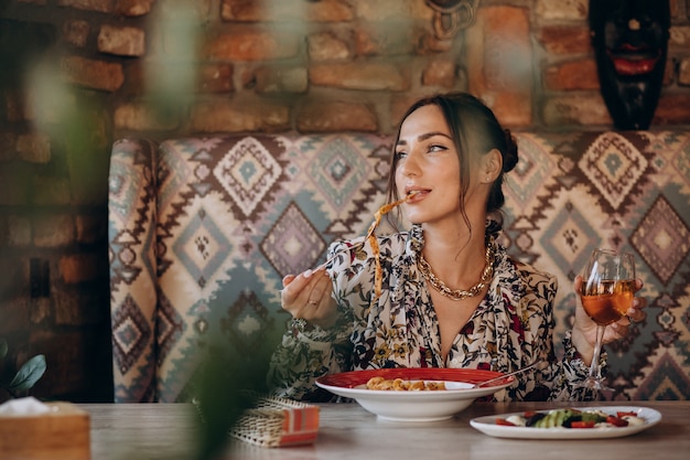 Donna che mangia pasta in un ristorante italiano