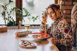 Free photo woman eating pasta in an italian restaurant