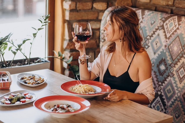 Donna che mangia pasta in un ristorante italiano