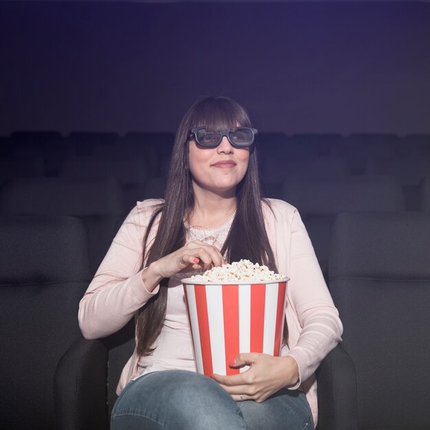 映画館でポップコーンを食べる女性