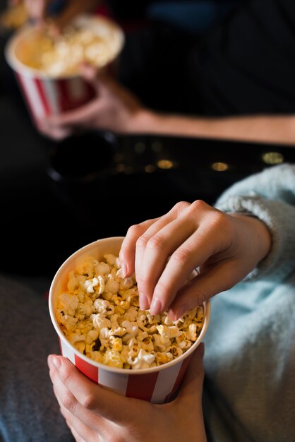 Женщина ест попкорн в кино