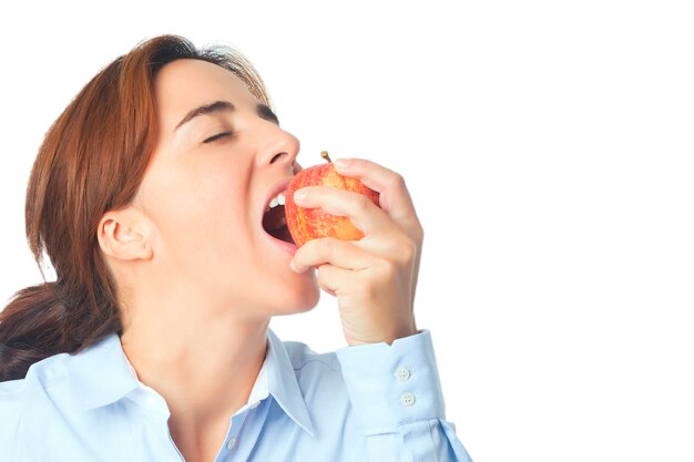 Женщина ест красное яблоко
