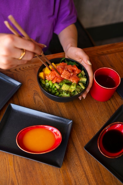 Free photo woman eating salmon dish bowl at the restaurant