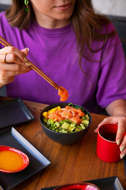 レストランでサーモン丼を食べる女性