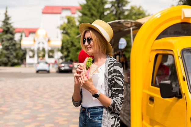 Woman eating a sandwich and looking away