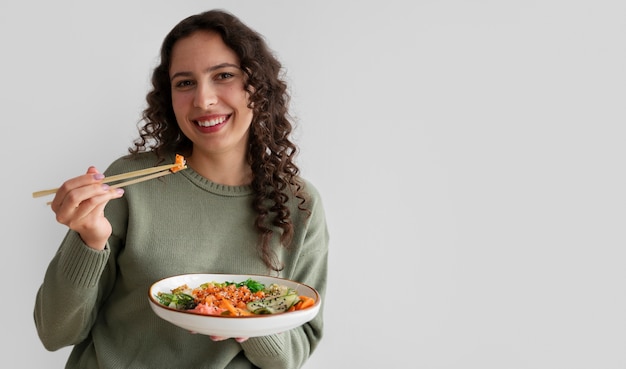 Foto gratuita donna che mangia piatto di frutti di mare con salmone