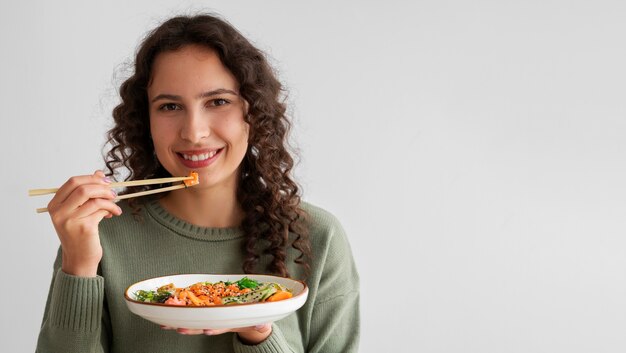サーモンの入ったシーフード料理を食べる女性