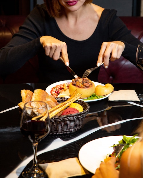 Woman eating stuffed baked quince at the restaurant