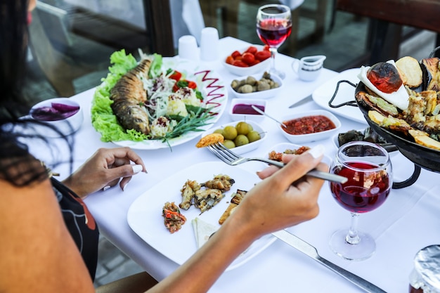 Woman eating various food while sitting in restaurant