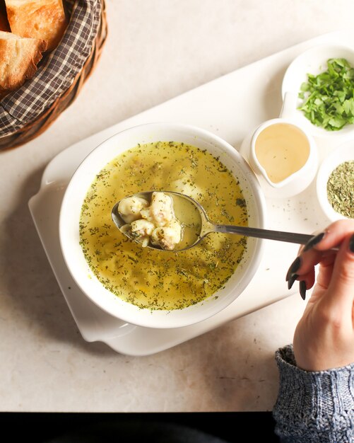 Woman eats dushbara served with dry herbs