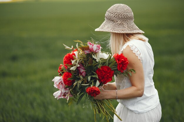 Woman in elegant dress standing in a summer field