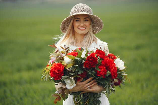 Женщина в элегантном платье, стоя в летнем поле