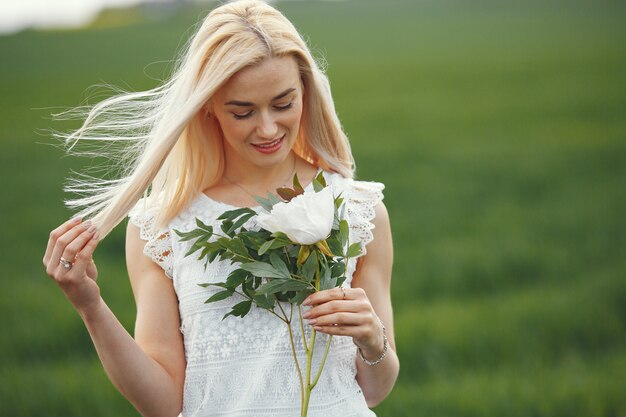 Woman in elegant dress standing in a summer field