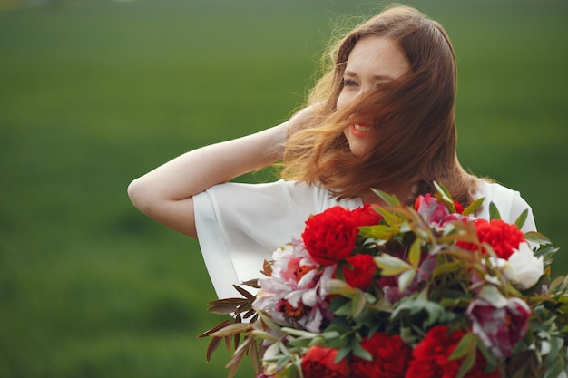 Woman in elegant dress standing in a summer field