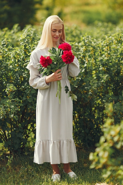 Woman in elegant dress standing in a summer field