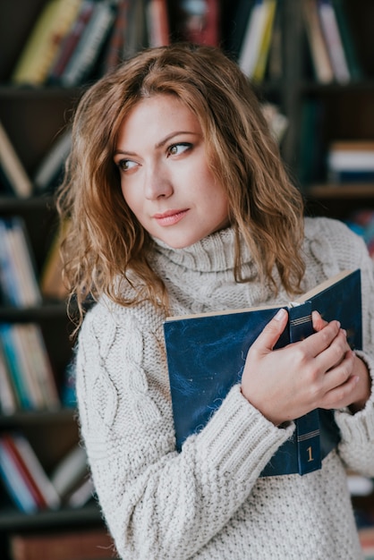 Woman embracing book and looking away