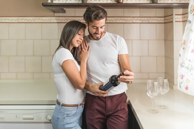 Woman embracing boyfriend with bottle of wine