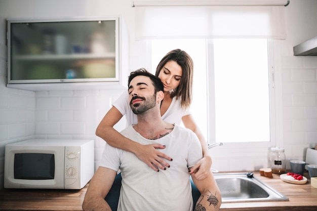Женщина обнимает человека на кухне