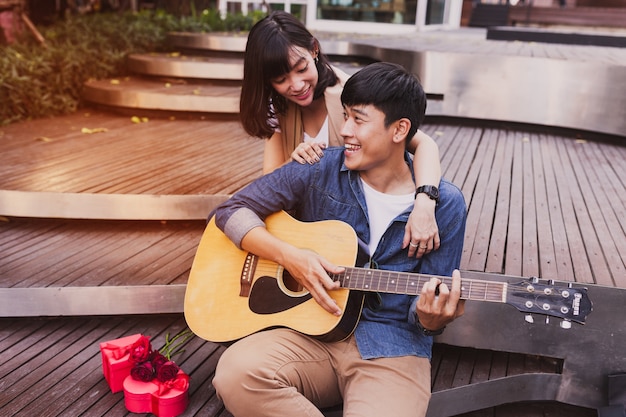 Free photo woman embracing a man while he plays guitar