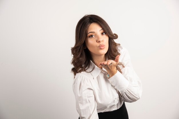 Woman employee blowing kiss on white.