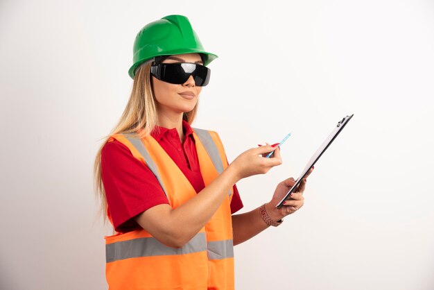 Woman employee showing with pencil on clipboard.