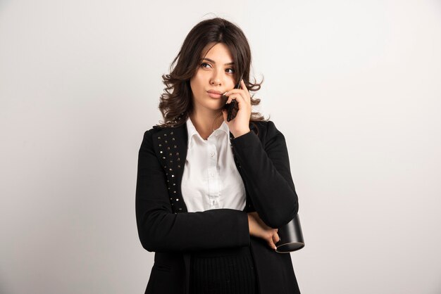 Woman employee talking on telephone on white