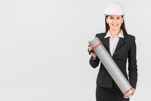 Woman engineer in helmet holding tube